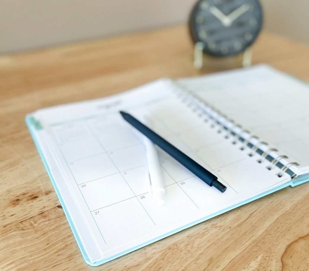 Open planner with a pen on a desk